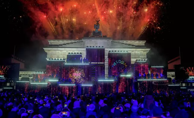 Fireworks light the sky as musicians play on stage during the concert for freedom for the 35th anniversary of the fall of the Berlin Wall, in Berlin, Germany, Saturday, Nov. 9, 2024. (AP Photo/Ebrahim Noroozi)