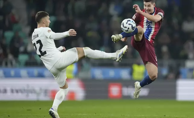 Slovenia's Adam Gnezda Cerin, left, and Norway's Lasse Johnsen go for the ball during the UEFA Nations League soccer match between Slovenia and Norway at Stozice stadium in Ljubljana, Slovenia, Thursday, Nov. 14, 2024. (AP Photo/Darko Bandic)