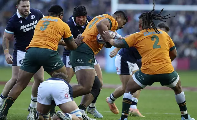 Australia's Will Skelton, center, is tackled by Scotland's Zander Fagerson, center rear, during the Autumn Nations series rugby union match between Scotland and Australia in Edinburgh, Sunday, Nov. 24, 2024.(AP Photo/Scott Heppell)