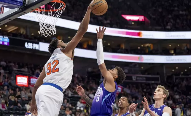 New York Knicks center Karl-Anthony Towns (32) blocks a shot from Utah Jazz guard Keyonte George (3) during the second half of an NBA basketball game, Saturday, Nov. 23, 2024, in Salt Lake City. (AP Photo/Spenser Heaps)