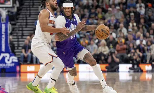 Utah Jazz guard Jordan Clarkson, right, drives against New York Knicks guard Jalen Brunson during the second half of an NBA basketball game, Saturday, Nov. 23, 2024, in Salt Lake City. (AP Photo/Spenser Heaps)