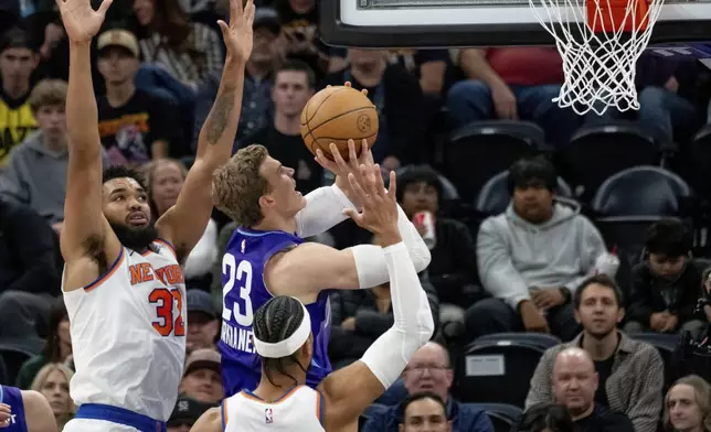 Utah Jazz forward Lauri Markkanen (23) goes to the hoop between New York Knicks center Karl-Anthony Towns, left, and guard Josh Hart during the first half of an NBA basketball game, Saturday, Nov. 23, 2024, in Salt Lake City. (AP Photo/Spenser Heaps)