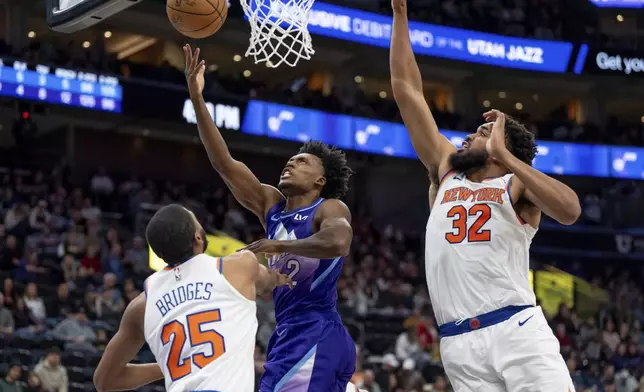 Utah Jazz guard Collin Sexton (2) goes to the hoop between New York Knicks forward Mikal Bridges (25) and center Karl-Anthony Towns (32) during the second half of an NBA basketball game, Saturday, Nov. 23, 2024, in Salt Lake City. (AP Photo/Spenser Heaps)