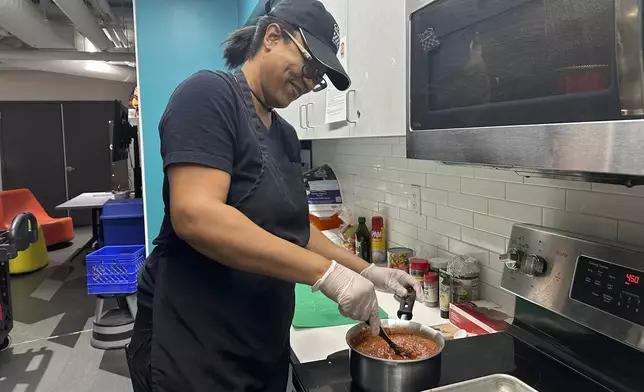 Chef Sharrie Agee prepares food as part of the Milwaukee Public Library’s Snack Hack program for kids on Nov. 19, 2024, Milwaukee. (AP Photo/Devi Shastri)