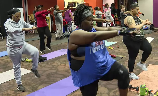 Attendees stretch during a fitness class at the public library in Kansas City, Mo., on Nov. 19, 2024. (AP Photo/Nick Ingram)