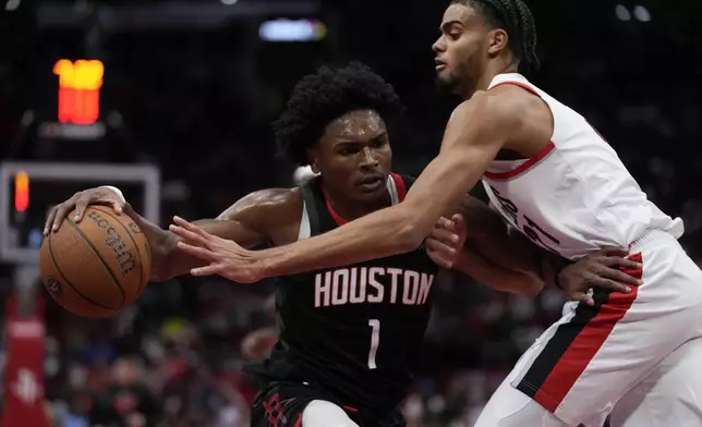 Portland Trail Blazers guard Rayan Rupert, right, defends against Houston Rockets forward Amen Thompson (1) during the second half of an Emirates NBA Cup basketball game in Houston, Friday, Nov. 22, 2024. (AP Photo/Ashley Landis)