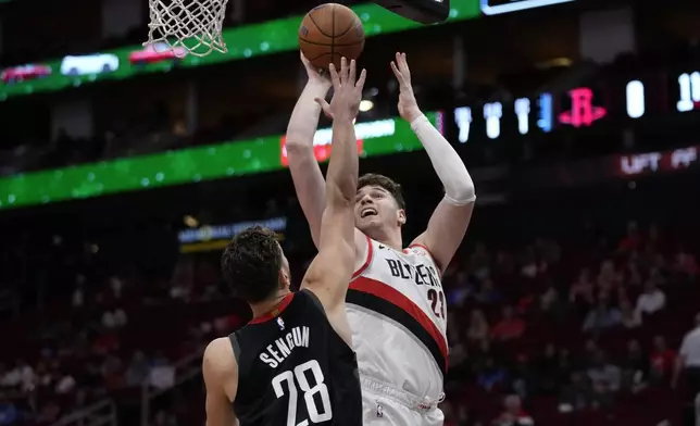 Portland Trail Blazers center Donovan Clingan, right, shoots against Houston Rockets center Alperen Sengun (28) during the first half of an Emirates NBA Cup basketball game in Houston, Friday, Nov. 22, 2024. (AP Photo/Ashley Landis)