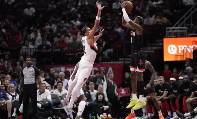 Houston Rockets guard Jalen Green (4) shoots a 3-pointer against Portland Trail Blazers forward Toumani Camara (33) during the first half of an Emirates NBA Cup basketball game in Houston, Friday, Nov. 22, 2024. (AP Photo/Ashley Landis)