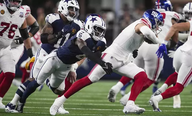 New York Giants quarterback Drew Lock (2) is sacked by Dallas Cowboys safety Donovan Wilson (6) and linebacker Micah Parsons (11) during the first half of an NFL football game in Arlington, Texas, Thursday, Nov. 28, 2024. (AP Photo/Tony Gutierrez)