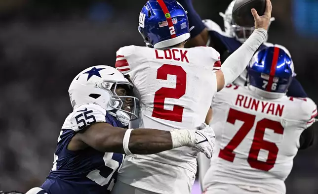 Dallas Cowboys defensive end Carl Lawson (55) sacks New York Giants quarterback Drew Lock (2) during the first half of an NFL football game in Arlington, Texas, Thursday, Nov. 28, 2024. (AP Photo/Jerome Miron)