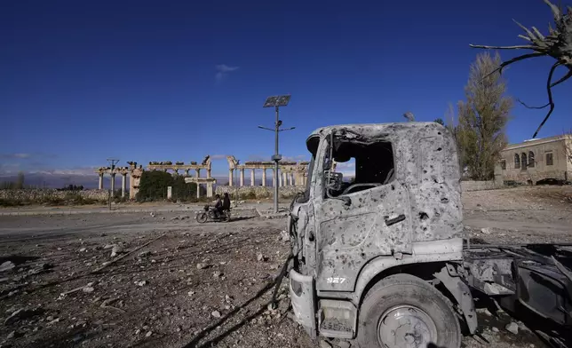 A damaged vehicle seen in front of part of the Roman temples of Baalbek in eastern Lebanon, Thursday, Nov. 28, 2024. (AP Photo/Hassan Ammar)