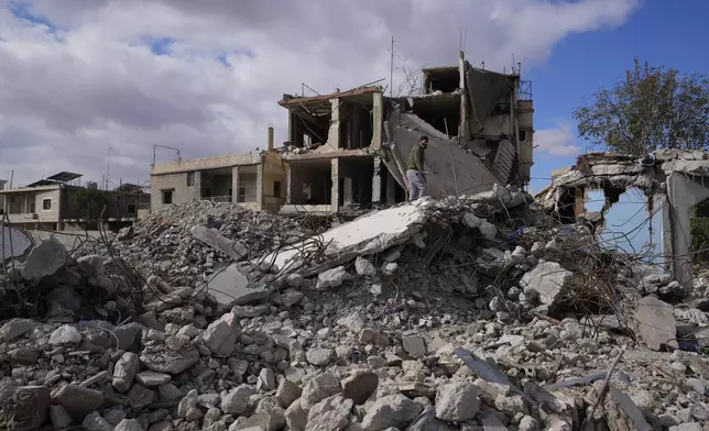 A man inspects a building destroyed in Israeli airstrikes in Baalbek, eastern Lebanon, Thursday, Nov. 28, 2024. (AP Photo/Hassan Ammar)