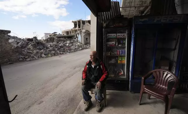 A man who was injured in Israeli airstrikes, sits in his shop near destroyed buildings in Baalbek, eastern Lebanon, Thursday, Nov. 28, 2024. (AP Photo/Hassan Ammar)