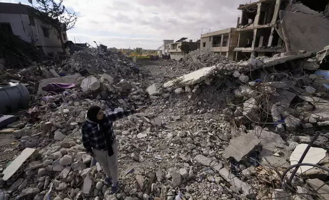 A woman inspects buildings destroyed in Israeli airstrikes in Baalbek, eastern Lebanon, Thursday, Nov. 28, 2024. (AP Photo/Hassan Ammar)