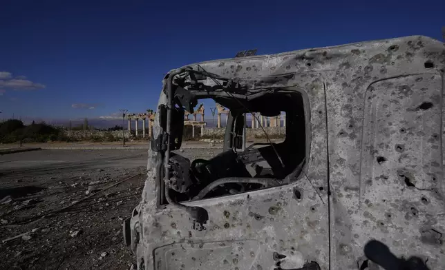 A damaged vehicle seen in front of part of the Roman temples of Baalbek in eastern Lebanon, Thursday, Nov. 28, 2024. (AP Photo/Hassan Ammar)