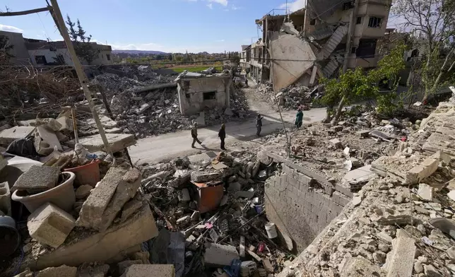 Residents check their destroyed neighborhood in Baalbek, eastern Lebanon, Thursday, Nov. 28, 2024. (AP Photo/Hassan Ammar)