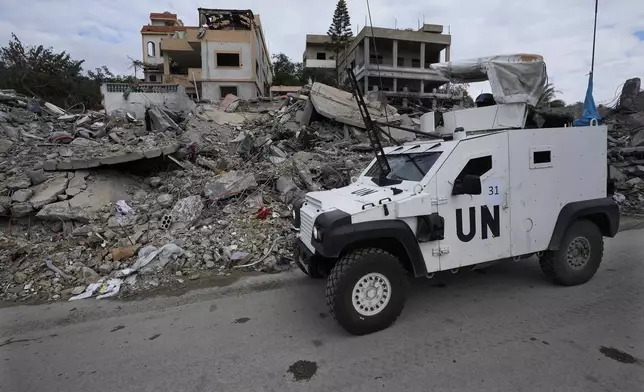 A South Korean U.N peacekeeper armoured vehicle drives by destroyed buildings in Chehabiyeh village, southern Lebanon, Thursday, Nov. 28, 2024 following a ceasefire between Israel and Hezbollah that went into effect on Wednesday. (AP Photo/Hussein Malla)