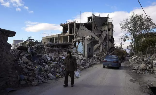 An elderly man walks near damaged buildings in Baalbek, eastern Lebanon, Thursday, Nov. 28, 2024. (AP Photo/Hassan Ammar)