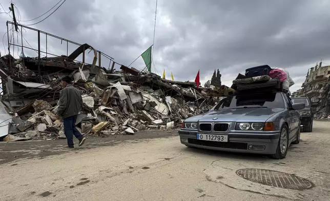 Displaced residents drive past destroyed buildings as they return to Nabatiyeh, southern Lebanon, Thursday, Nov. 28, 2024 following a ceasefire between Israel and Hezbollah that went into effect on Wednesday. (AP Photo/Bassam Hatoum)