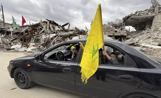 A boy holds a Hezbollah's flag, as displaced residents return to Nabatiyeh, southern Lebanon, Thursday, Nov. 28, 2024 following a ceasefire between Israel and Hezbollah that went into effect on Wednesday. (AP Photo/Bassam Hatoum)