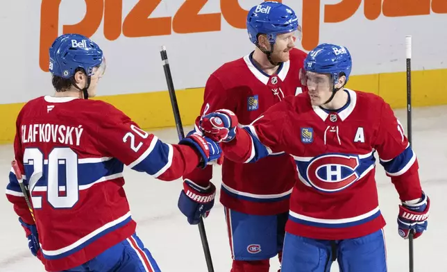 Montreal Canadiens' Brendan Gallagher (11) celebrates after his goal against the Edmonton Oilers with teammates Mike Matheson (8) and Juraj Slafkovsky (20) during second-period NHL hockey game action in Montreal, Monday, Nov. 18, 2024. (Christinne Muschi/The Canadian Press via AP)