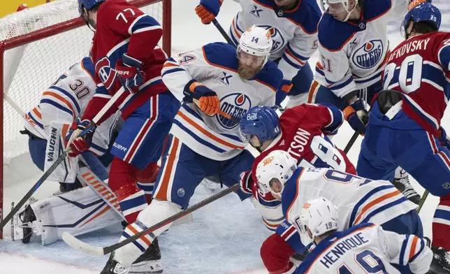 Montreal Canadiens' Lane Hutson (48) looks for the rebound in front of Edmonton Oilers' goaltender Calvin Pickard (30) during the first period of an NHL hockey game in Montreal, Monday, Nov. 18, 2024. (Christinne Muschi/The Canadian Press via AP)