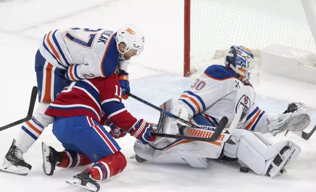 Edmonton Oilers goaltender Calvin Pickard (30) looks for the puck as Montreal Canadiens' Brendan Gallagher (11) is stopped by Oilers' Brett Kulak (27) during second-period NHL hockey game action in Montreal, Monday, Nov. 18, 2024. (Christinne Muschi/The Canadian Press via AP)