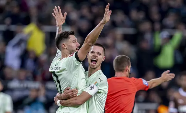 Moenchengladbach's Tim Kleindienst, left, celebrates with Julian Weigl after scoring his side's second goal during the German Bundesliga soccer match between Borussia Moenchengladbach and FC St. Pauli at the Borussia Park in Moenchengladbach, Germany, Sunday, Nov. 24, 2024. (David Inderlied/dpa via AP)