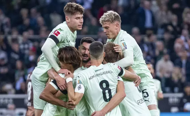 Moenchengladbach's players celebrate after scoring the opening goal during the German Bundesliga soccer match between Borussia Moenchengladbach and FC St. Pauli at the Borussia Park in Moenchengladbach, Germany, Sunday, Nov. 24, 2024. (David Inderlied/dpa via AP)