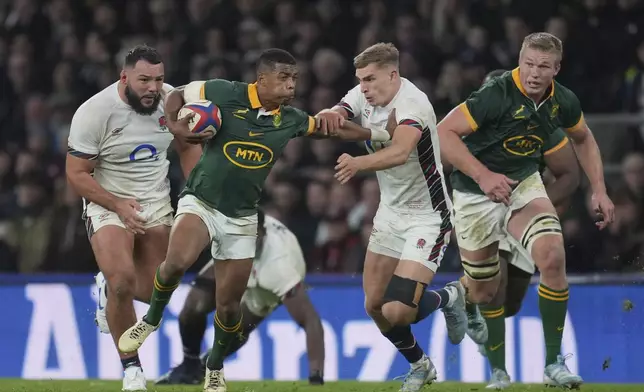 South Africa's Grant Williams fends off the challenge by England's Jack van Poortvliet during the Autumn Nations series rugby union match between England and South Africa, at Twickenham, in London, Saturday, Nov. 16, 2024. (AP Photo/Kin Cheung)