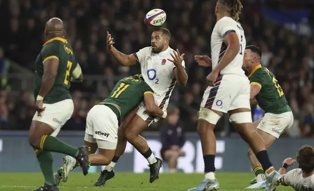 England's Ollie Lawrence loose the ball as he is tackled by South Africa's Kurt-Lee Arendse during the Autumn Nations series rugby union match between England and South Africa, at Twickenham, in London, Saturday, Nov. 16, 2024. (AP Photo/Ian Walton)