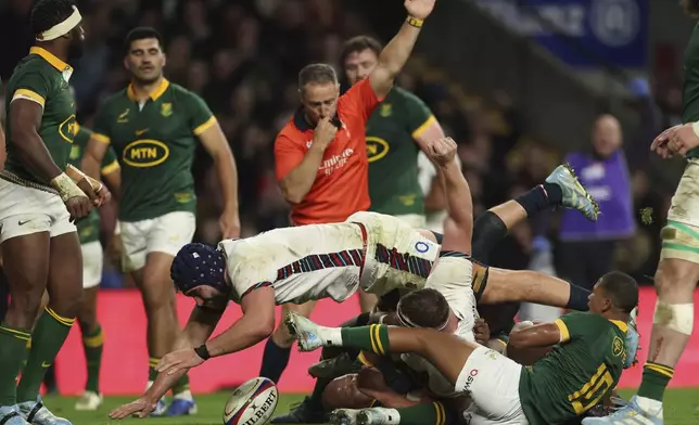 Referee Andrew Brace indicates a try as England's Sam Underhill, raises his arm to celebrate after he scores during the Autumn Nations series rugby union match between England and South Africa, at Twickenham, in London, Saturday, Nov. 16, 2024. (AP Photo/Ian Walton)