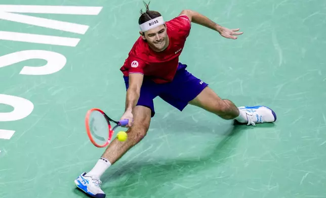 Taylor Fritz of the United States returns the ball to Australia's Alex de Minaur during a Davis Cup quarterfinal match at the Martin Carpena Sports Hall, in Malaga, southern Spain, on Thursday, Nov. 21, 2024. (AP Photo/Manu Fernandez)