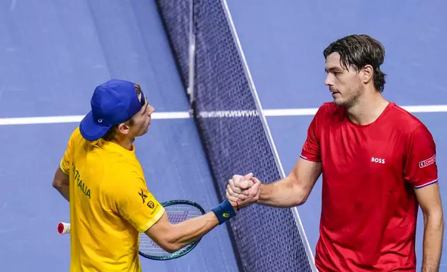 Taylor Fritz of the United States, right, shakes hands afer defeating Australia's Alex de Minaur during a Davis Cup quarterfinal match at the Martin Carpena Sports Hall, in Malaga, southern Spain, on Thursday, Nov. 21, 2024. (AP Photo/Manu Fernandez)