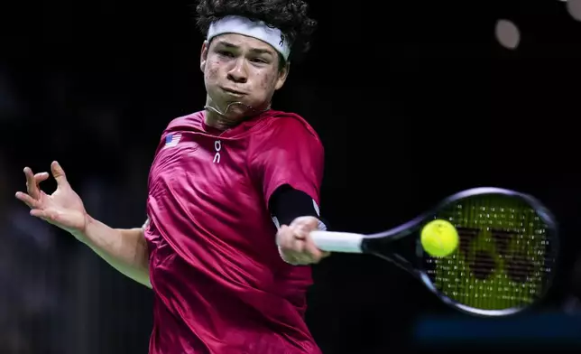 Ben Shelton of the United States returns the ball to Australia's Athanasios Kokkinakis during a Davis Cup quarterfinal match at the Martin Carpena Sports Hall, in Malaga, southern Spain, on Thursday, Nov. 21, 2024. (AP Photo/Manu Fernandez)