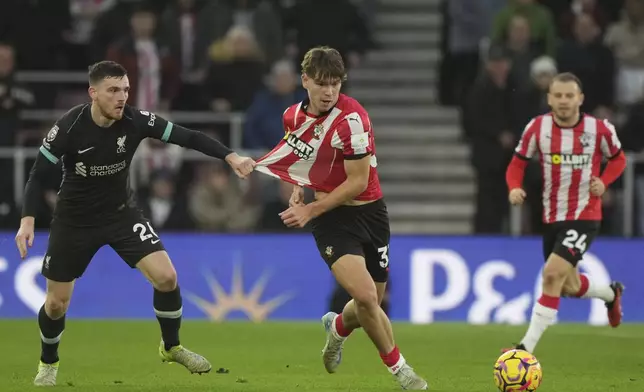 Liverpool's Andrew Robertson holds Southampton's Tyler Dibling during the English Premier League soccer match between Southampton and Liverpool in Southampton, England, Sunday, Nov. 24, 2024. (AP Photo/Sean Ryan)