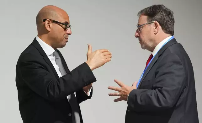 Simon Stiell, United Nations climate chief, left, talks with Achim Steiner, United Nations development programme administrator, at the COP29 U.N. Climate Summit, Wednesday, Nov. 13, 2024, in Baku, Azerbaijan. (AP Photo/Peter Dejong)