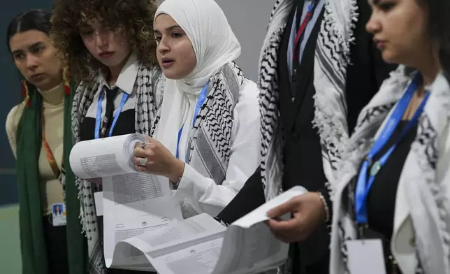 Activists say they read names of victims of genocide during a demonstration at the COP29 U.N. Climate Summit, Thursday, Nov. 14, 2024, in Baku, Azerbaijan. (AP Photo/Peter Dejong)