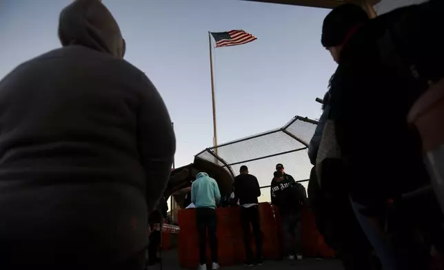 FILE - Migrants line up to present to U.S. agents, documents requesting an appointment to apply for asylum, at the Paso del Norte international bridge, in Ciudad Juarez, Mexico, Nov 5, 2024. (AP Photo/Christian Chavez, File)