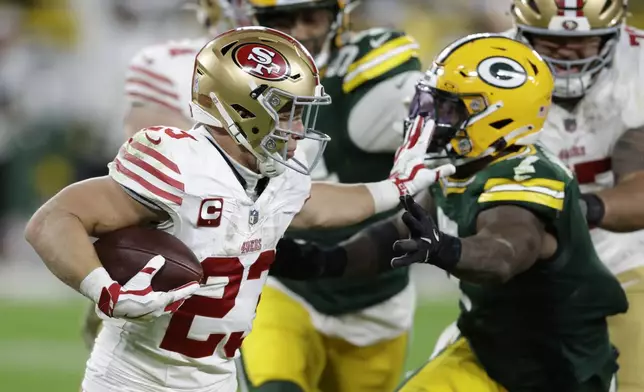 San Francisco 49ers running back Christian McCaffrey (23) stops Green Bay Packers linebacker Quay Walker (7) during the second half of an NFL football game on Sunday, Nov. 24, 2024 in Green Bay, Wis. (AP Photo/Matt Ludtke)