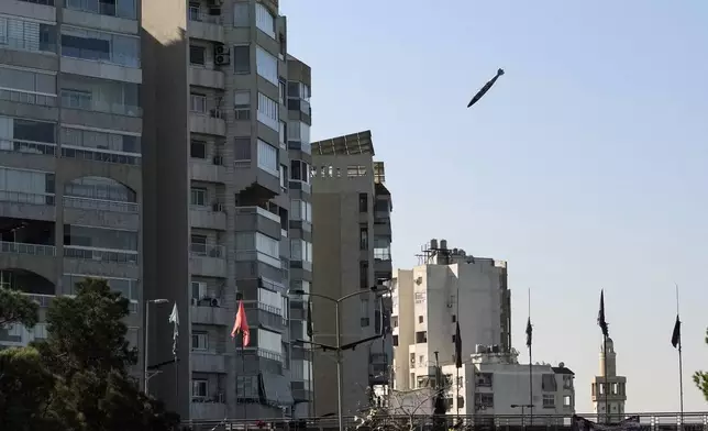 A bomb dropped from an Israeli jet prepares to hit a building in Tayouneh, Beirut, Lebanon, Friday, Nov. 15, 2024. (AP Photo/Hassan Ammar)