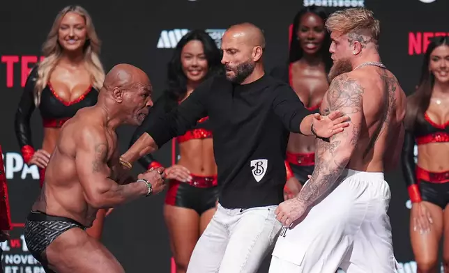 Promoter Nakisa Bidarian, center, co-founder of Most Valuable Promotions, steps in the way of Mike Tyson, left, after Tyson slapped Jake Paul during a weigh-in ahead of their heavyweight bout, Thursday, Nov. 14, 2024, in Irving, Texas. (AP Photo/Julio Cortez)