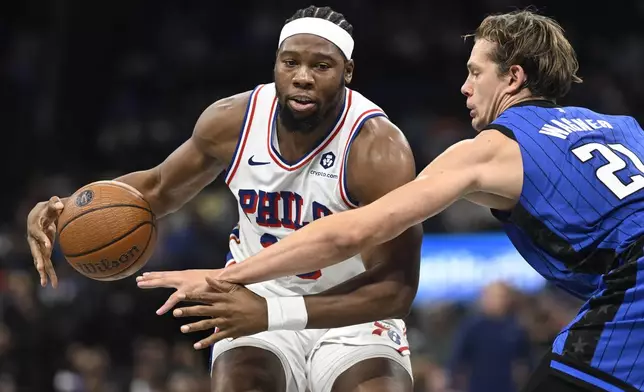 Orlando Magic center Moritz Wagner (21) pokes the ball loose from Philadelphia 76ers forward Guerschon Yabusele, left, during the second half of an Emirates NBA Cup basketball game, Friday, Nov. 15, 2024, in Orlando, Fla. (AP Photo/Phelan M. Ebenhack)