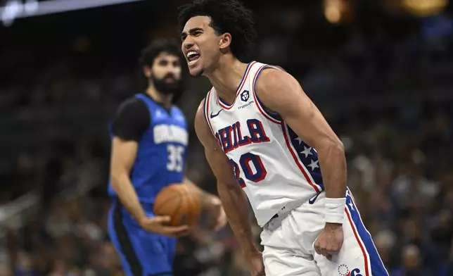 Philadelphia 76ers guard Jared McCain (20) celebrates after scoring as Orlando Magic center Goga Bitadze (35) looks on during the second half of an Emirates NBA Cup basketball game, Friday, Nov. 15, 2024, in Orlando, Fla. (AP Photo/Phelan M. Ebenhack)