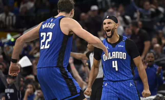 Orlando Magic forward Franz Wagner (22) and guard Jalen Suggs (4) celebrate after a 3-point basket by Suggs during the second half of an Emirates NBA Cup basketball game against the Philadelphia 76ers, Friday, Nov. 15, 2024, in Orlando, Fla. (AP Photo/Phelan M. Ebenhack)