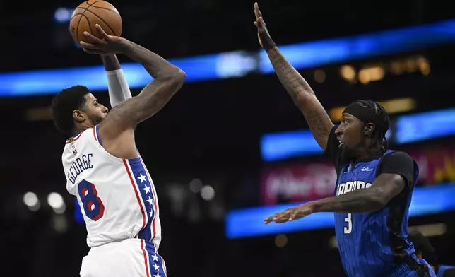 Philadelphia 76ers forward Paul George (8) shoots in front of Orlando Magic guard Kentavious Caldwell-Pope (3) during the second half of an Emirates NBA Cup basketball game, Friday, Nov. 15, 2024, in Orlando, Fla. (AP Photo/Phelan M. Ebenhack)