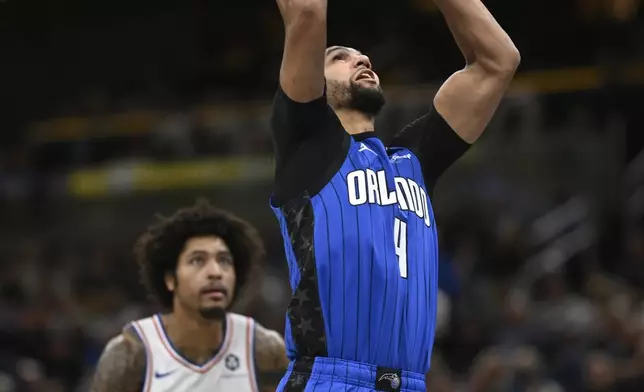 Orlando Magic guard Jalen Suggs (4) goes up to shoot in front of Philadelphia 76ers guard Kelly Oubre Jr. (9) during the first half of an Emirates NBA Cup basketball game, Friday, Nov. 15, 2024, in Orlando, Fla. (AP Photo/Phelan M. Ebenhack)