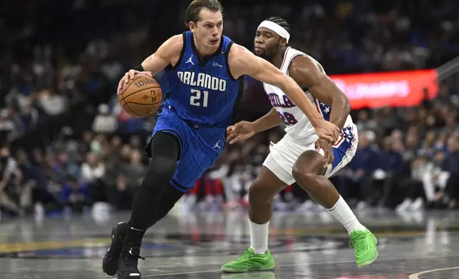 Orlando Magic center Moritz Wagner (21) drives past Philadelphia 76ers forward Guerschon Yabusele (28) during the first half of an Emirates NBA Cup basketball game, Friday, Nov. 15, 2024, in Orlando, Fla. (AP Photo/Phelan M. Ebenhack)