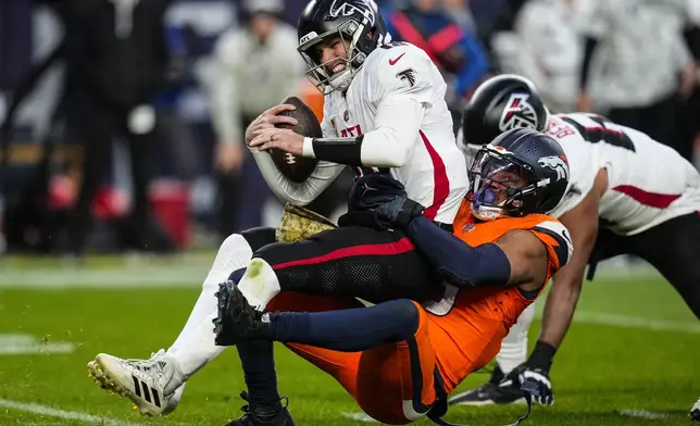 Denver Broncos linebacker Nik Bonitto (15) sacks Atlanta Falcons quarterback Kirk Cousins (18) during the second half of an NFL football game, Sunday, Nov. 17, 2024, in Denver. (AP Photo/David Zalubowski)