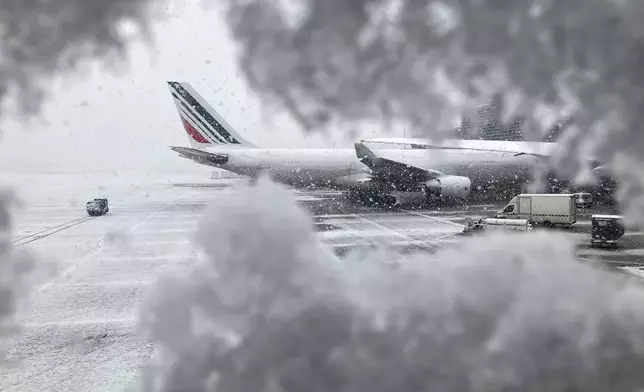 An Air France plane sits on the tarmac during a snowfall at Charles de Gaulle airport, north of Paris, Thursday, Nov. 21, 2024. (AP Photo/Masha Macpherson)